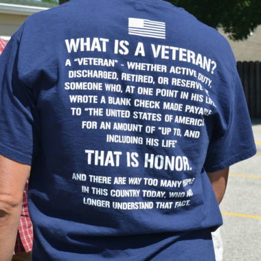 Back of Pearly Gates Ride attendee wearing a shirt describing what a Veteran is and what it means.